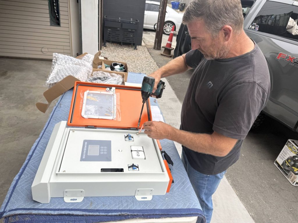 Opening the front panel of the Elejoy V2H inverter with a drill before mounting it