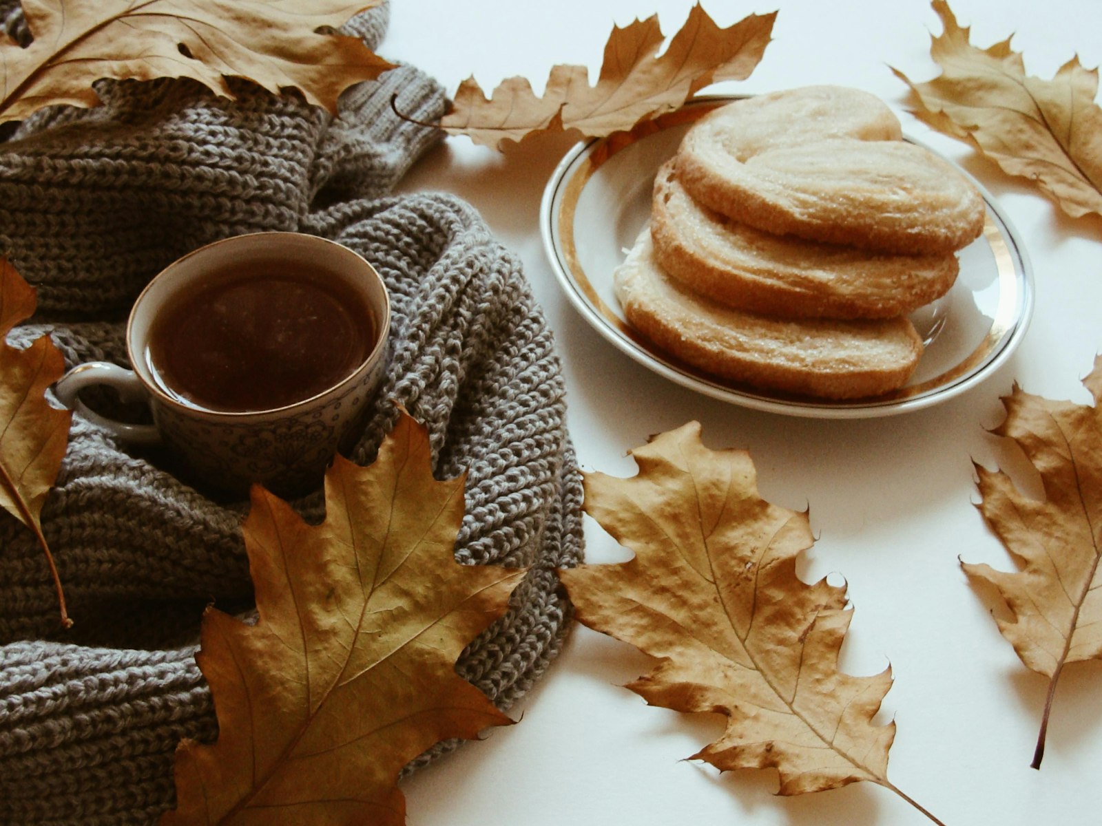 Cozy autumn table with tea and fallen leaves