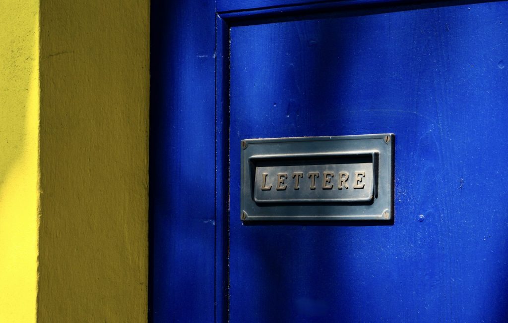 Blue front door with a metal letterbox