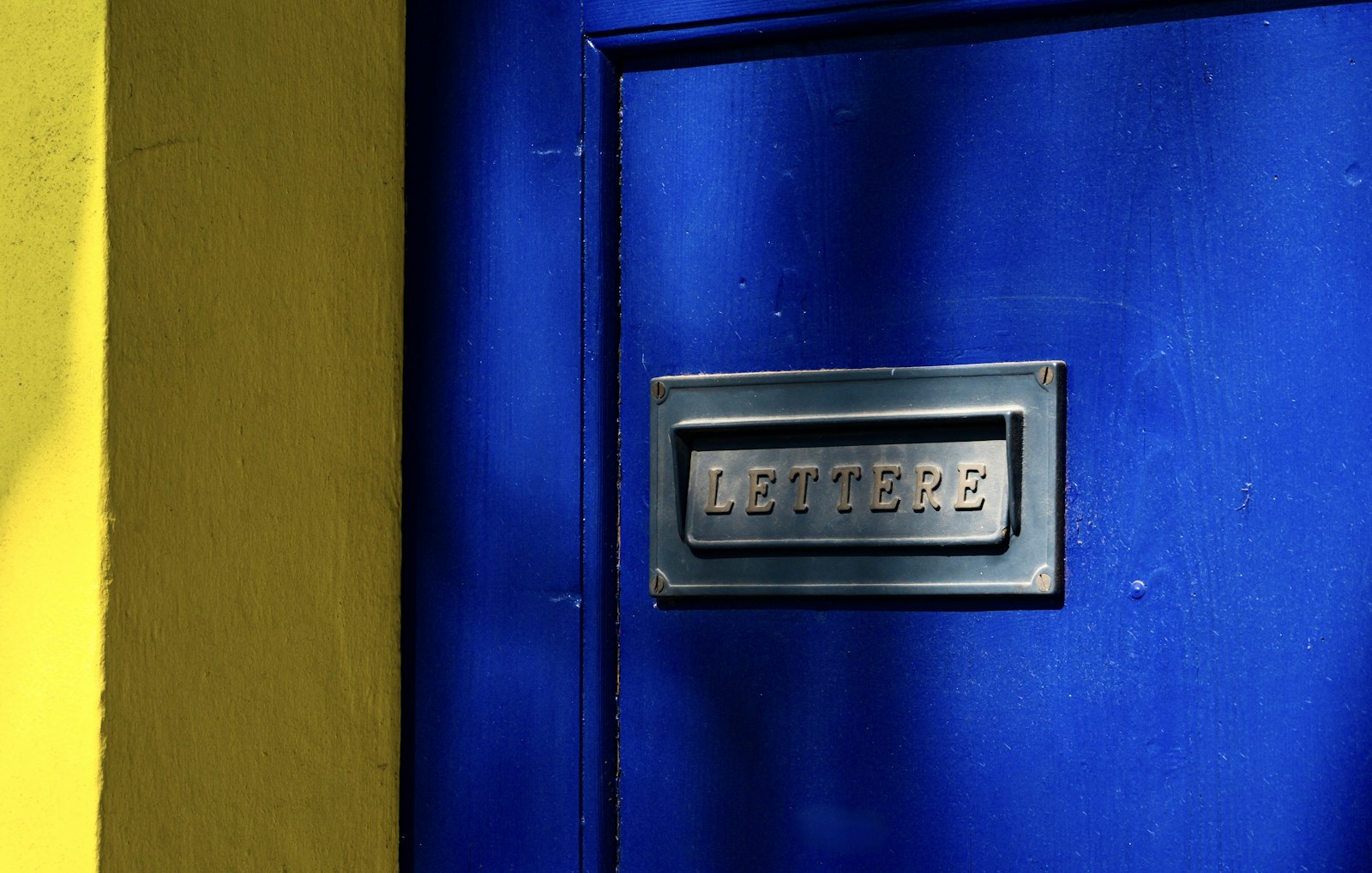 Blue front door with a metal letterbox