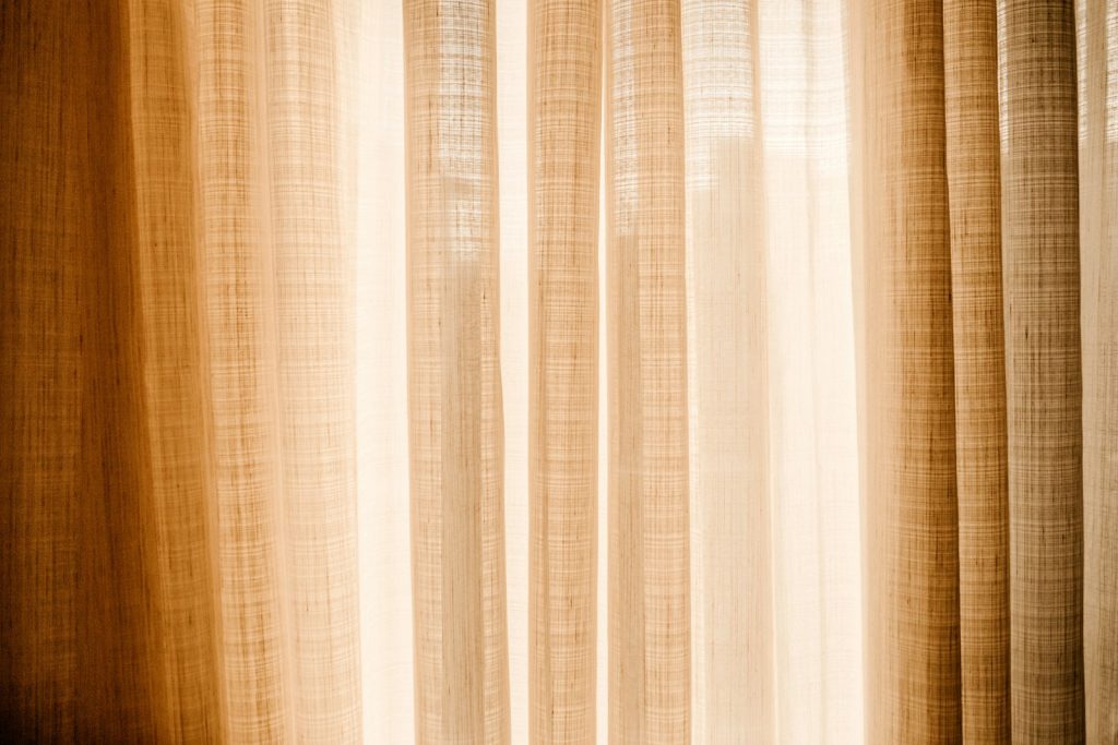 Sunlight through a window with a sheer curtain