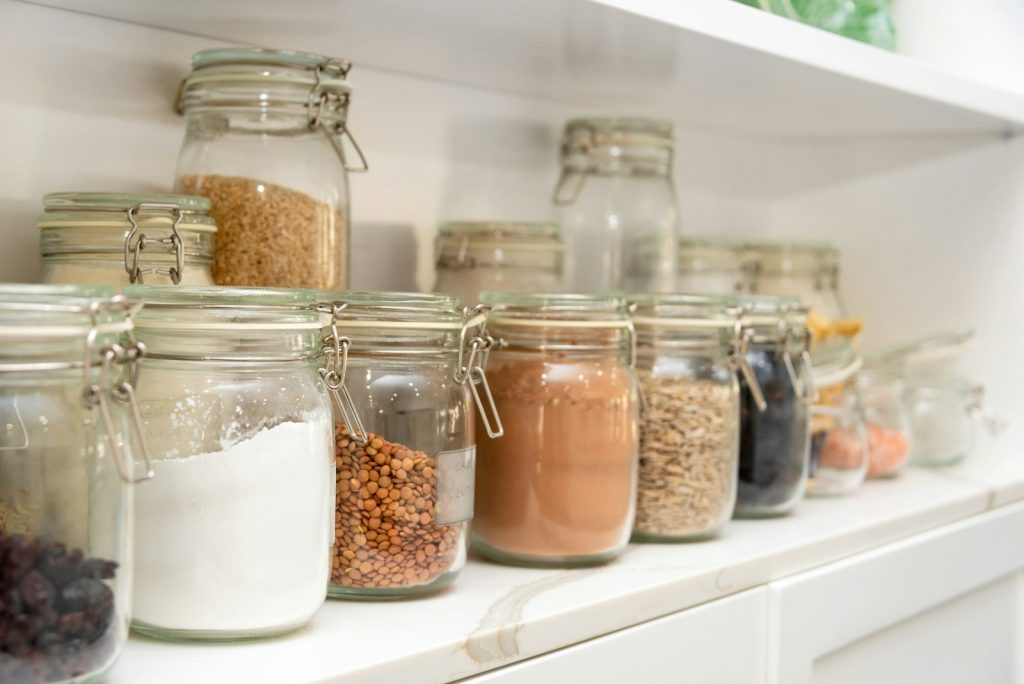 Clear jars of food on a pantry shelf