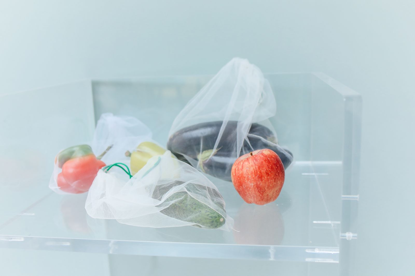 Reusable mesh produce bags filled with fresh vegetables